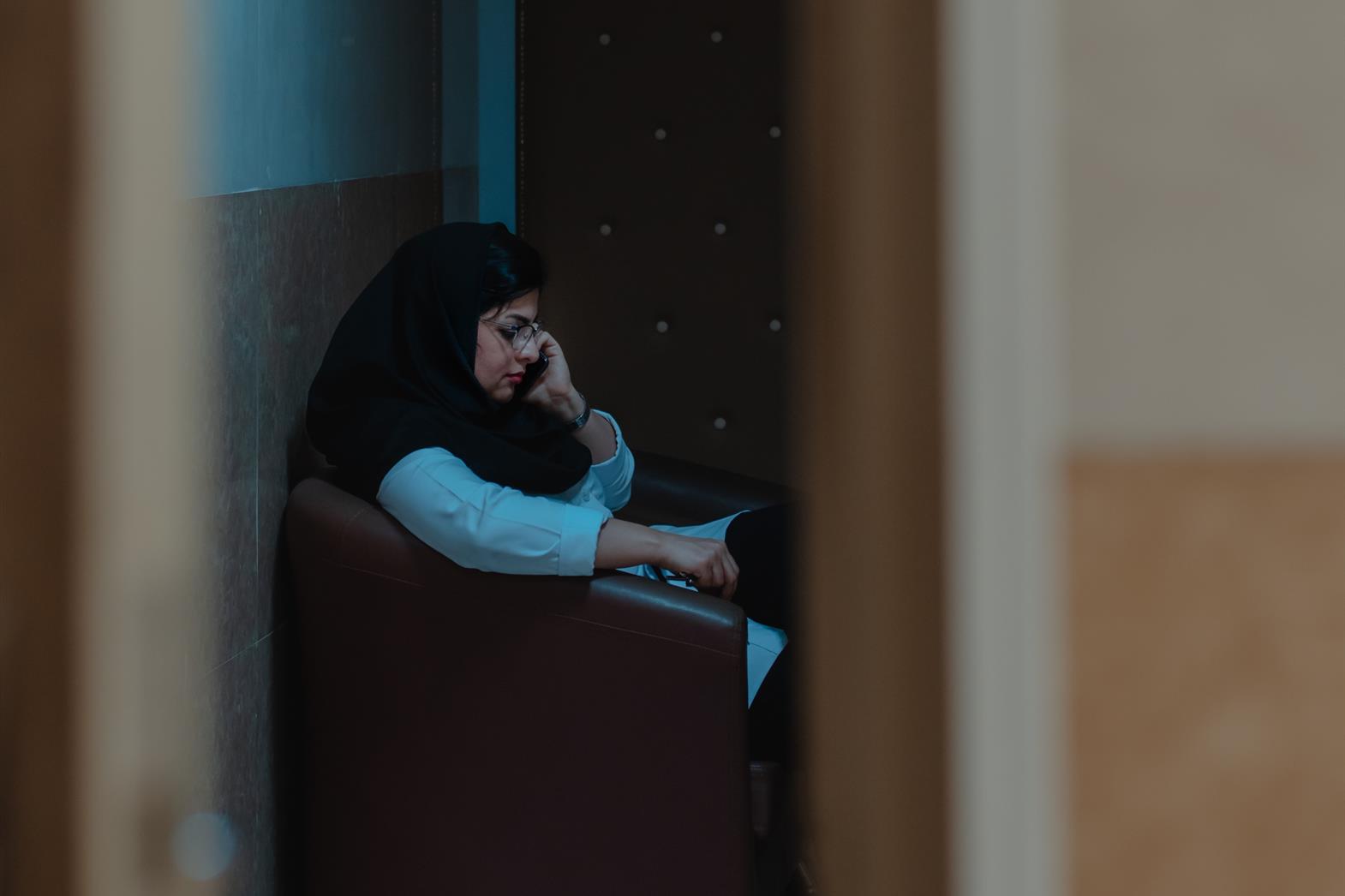 Les femmes qui attendent dans une chaise au téléphone