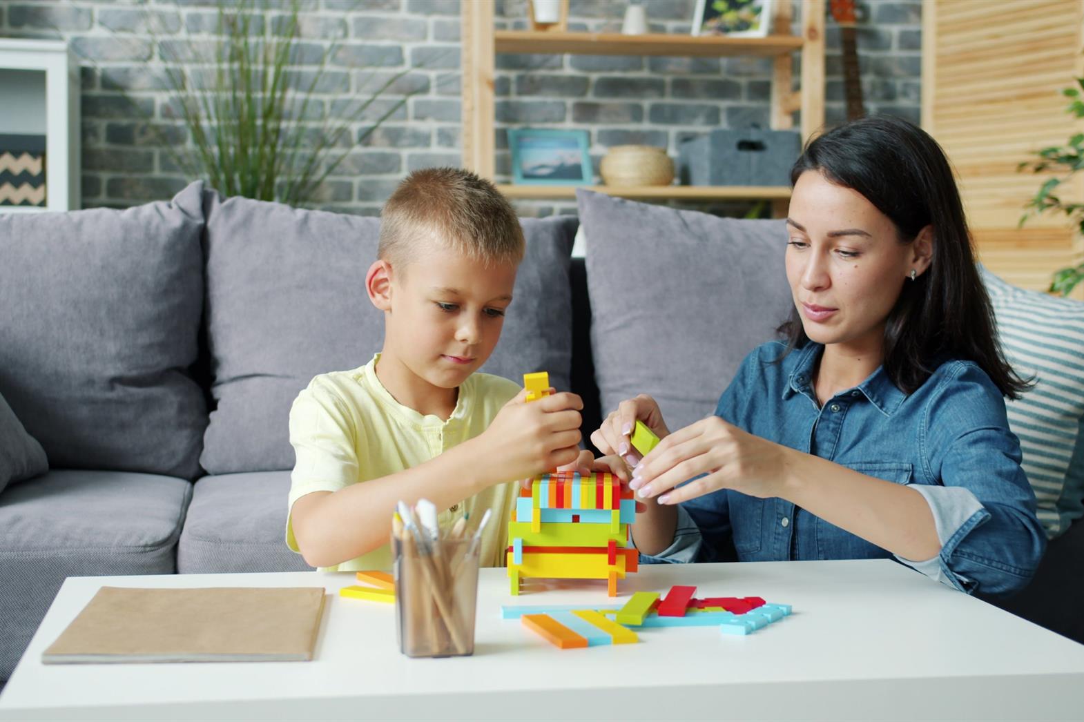 A mother and son engaging in a creative building activity at home