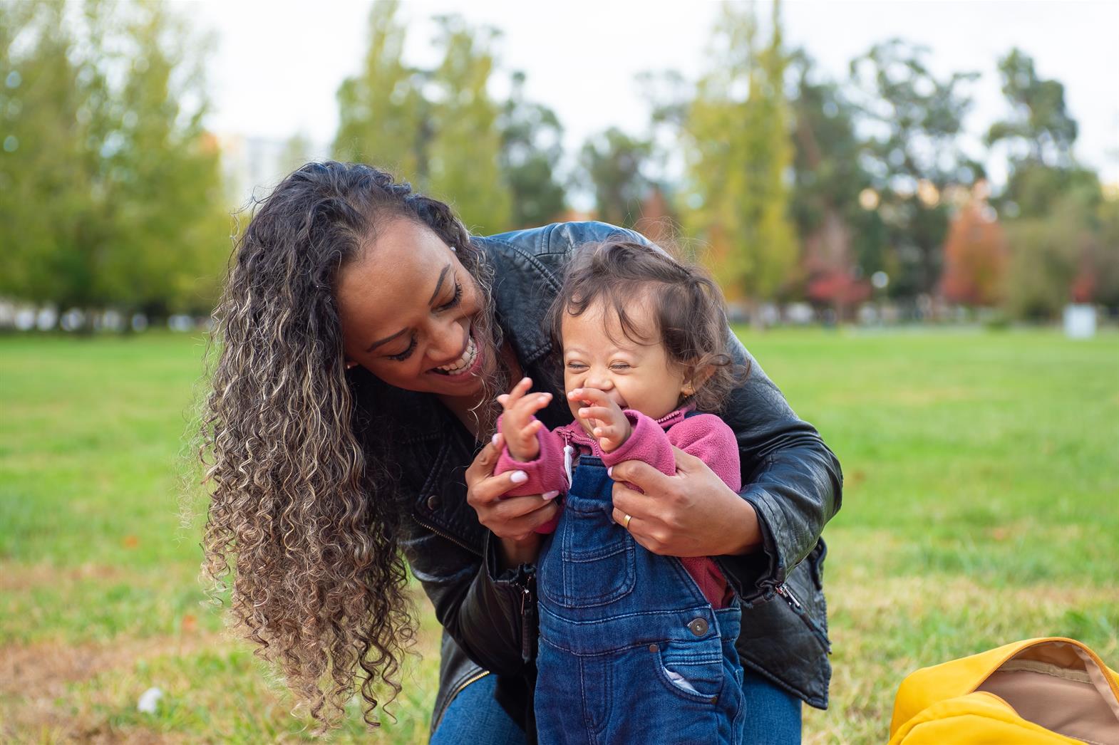 A mother and daughter playing outdoors in a park