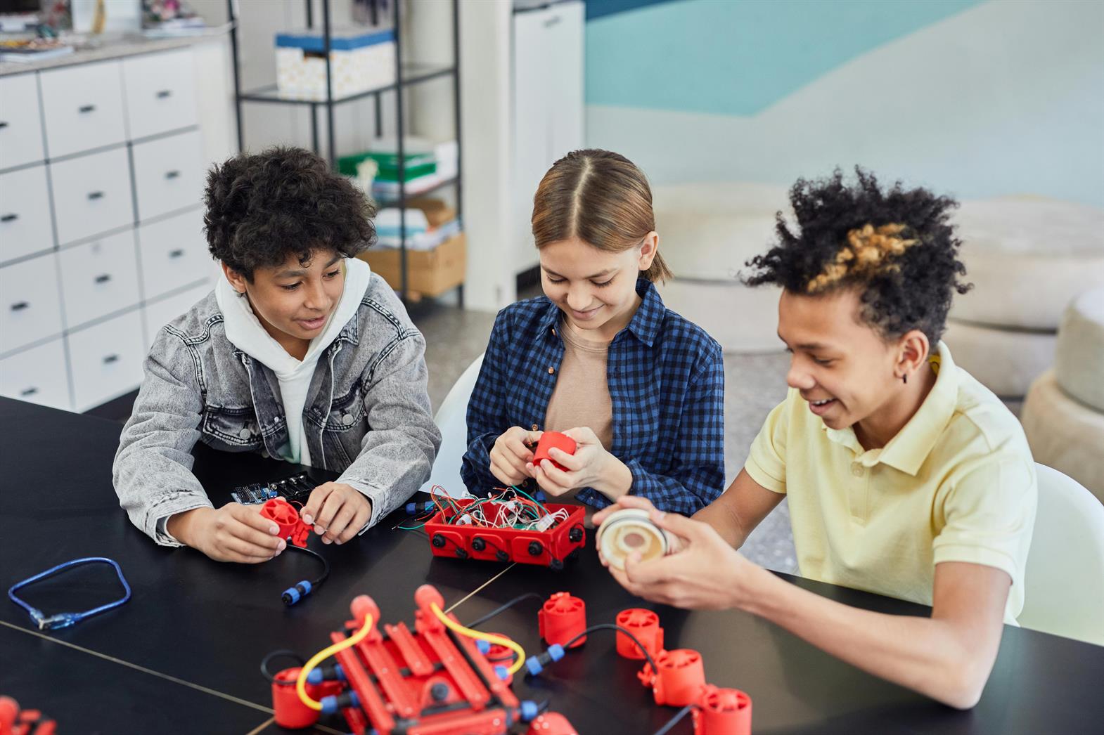 A group of teens working on a robotics kit together