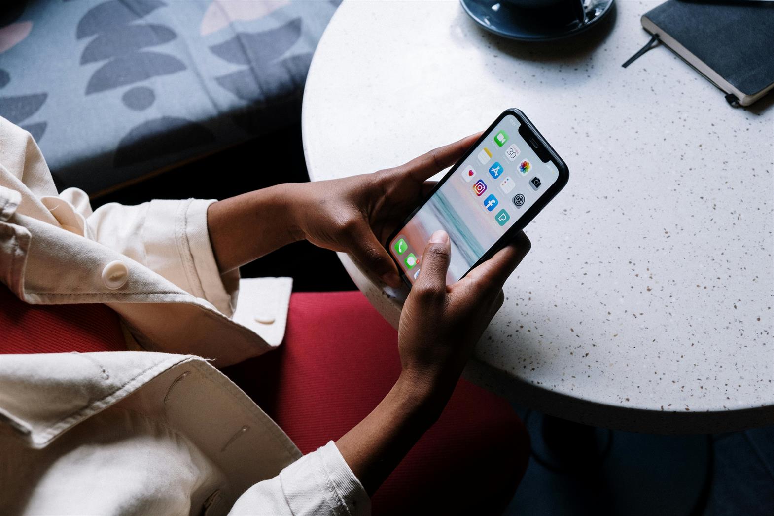 Person looking at social media icons on an iphone