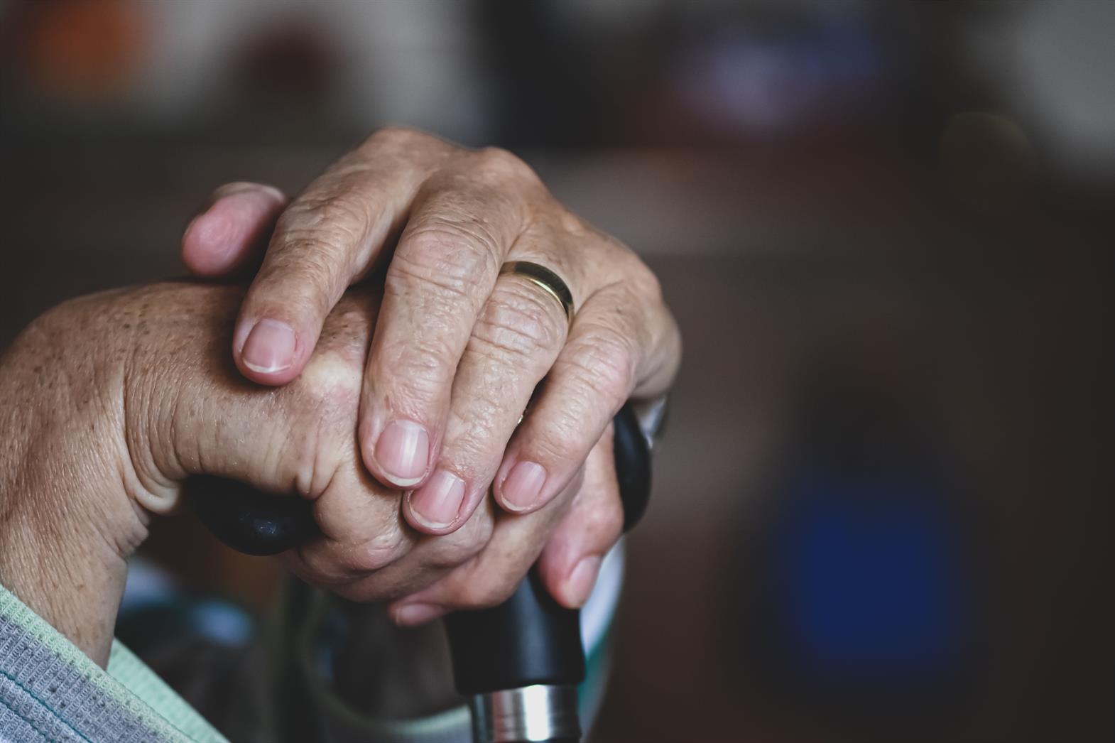 Les mains d'une personne âgée posées sur une canne