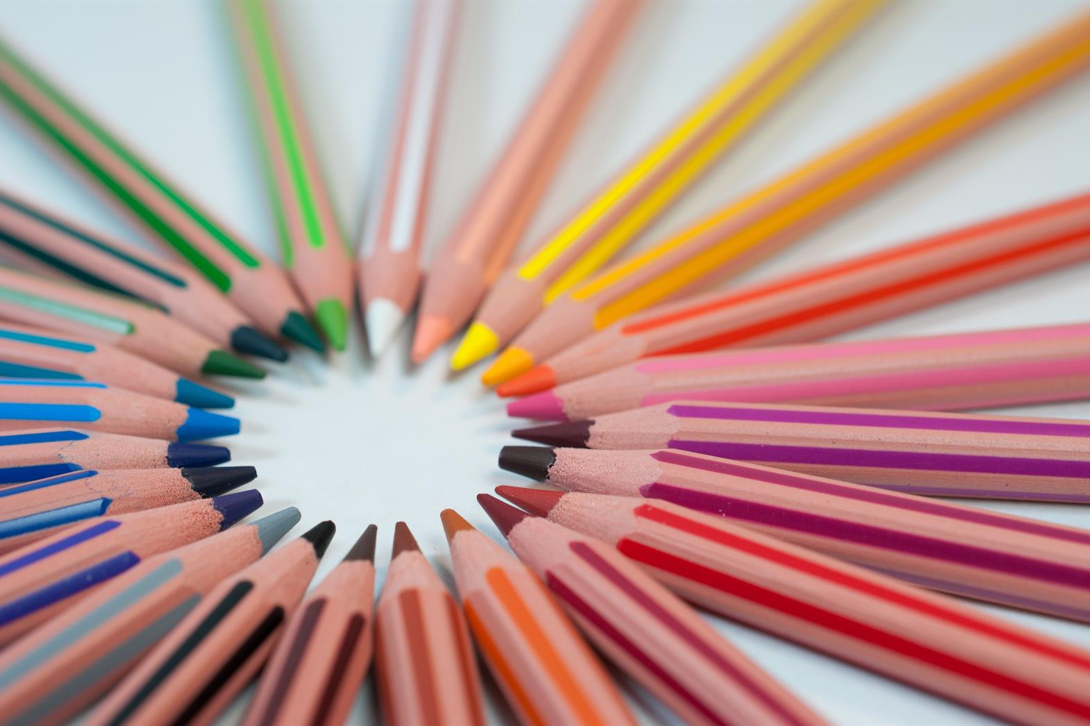 Colored pencils arranged in a circle on a white background