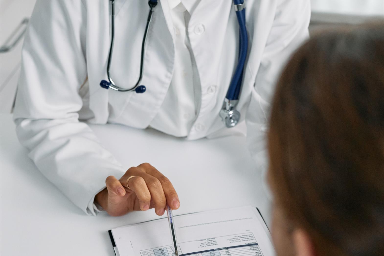 A doctor shows a patient a piece of paper