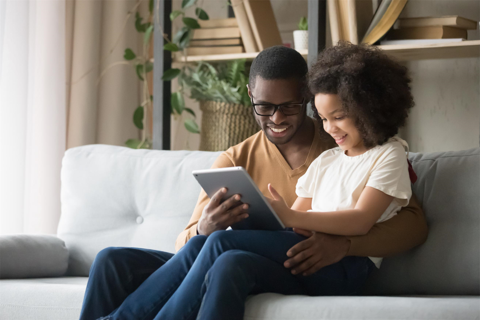 A father and daughter looking at a tablet together