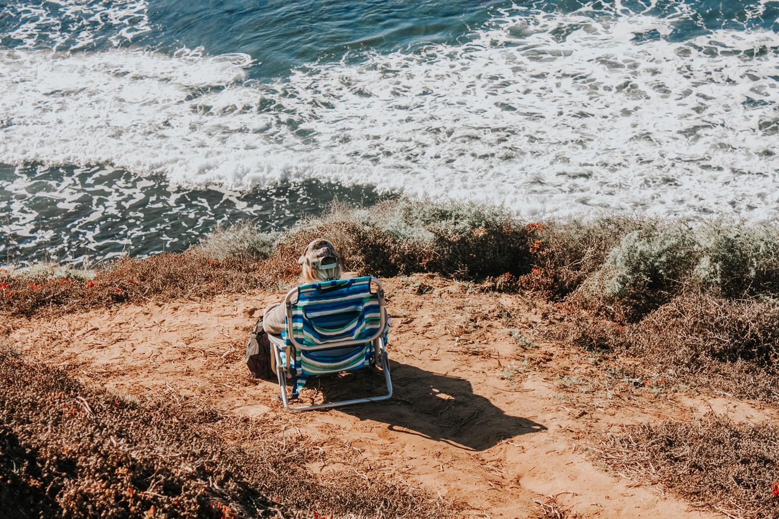 Une personne assise sur une chaise au bord de la mer