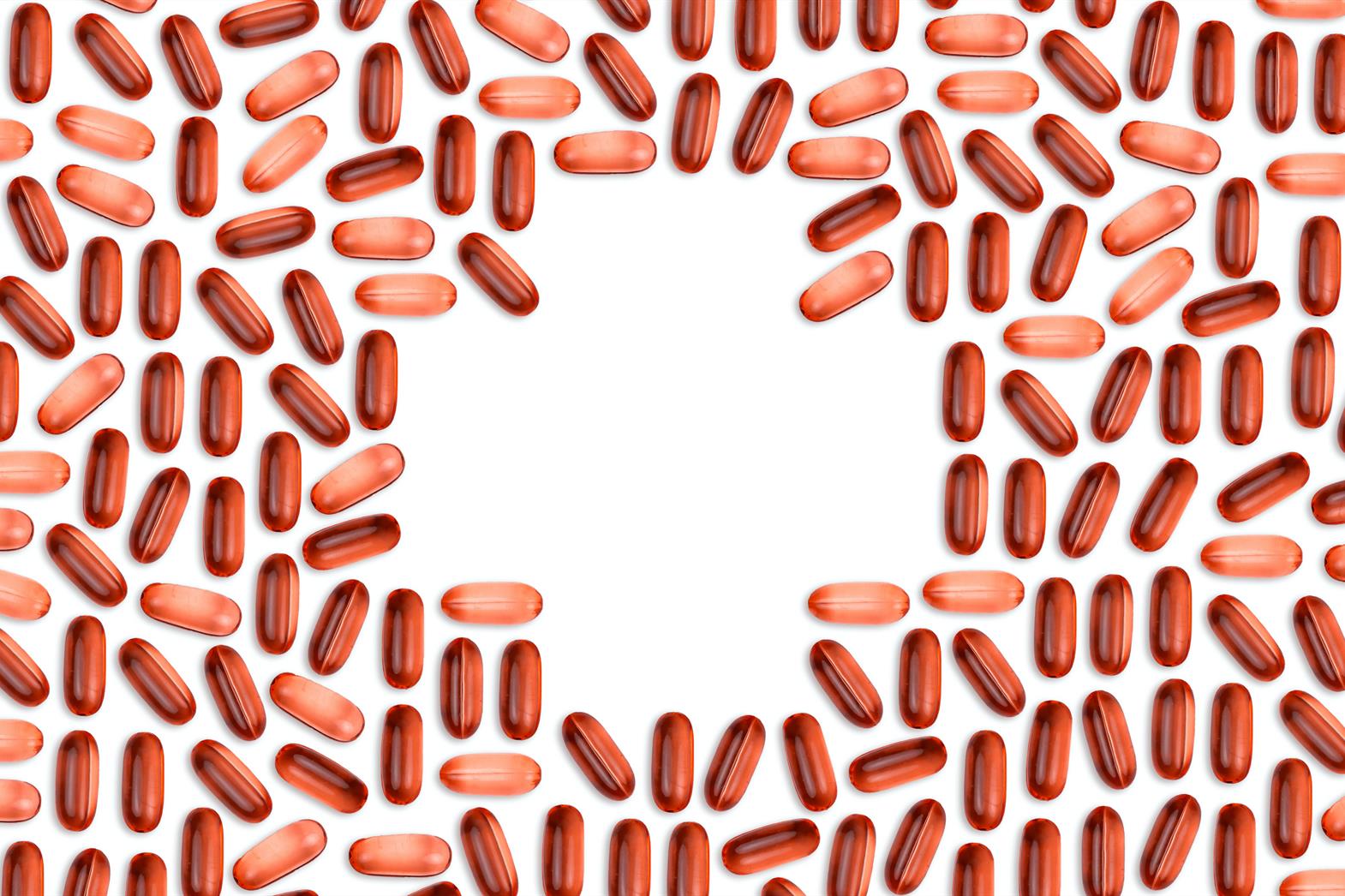 Red tablets placed in pattern to form a cross on a white background