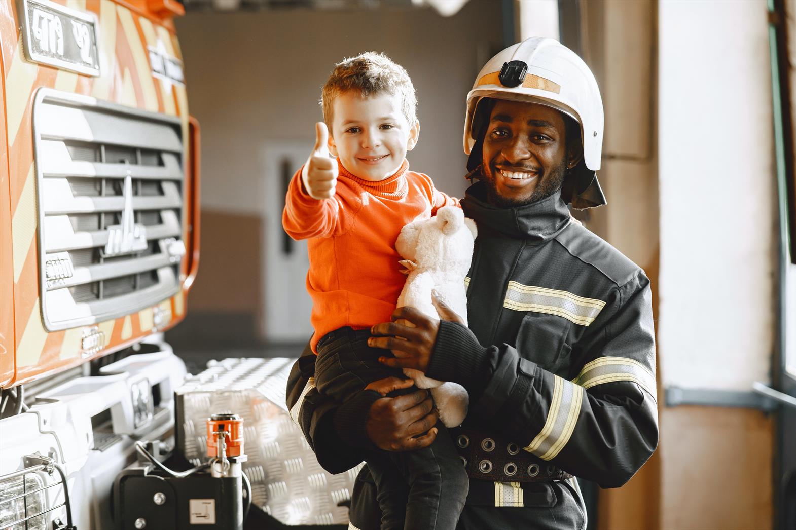A firefighter carrying a child