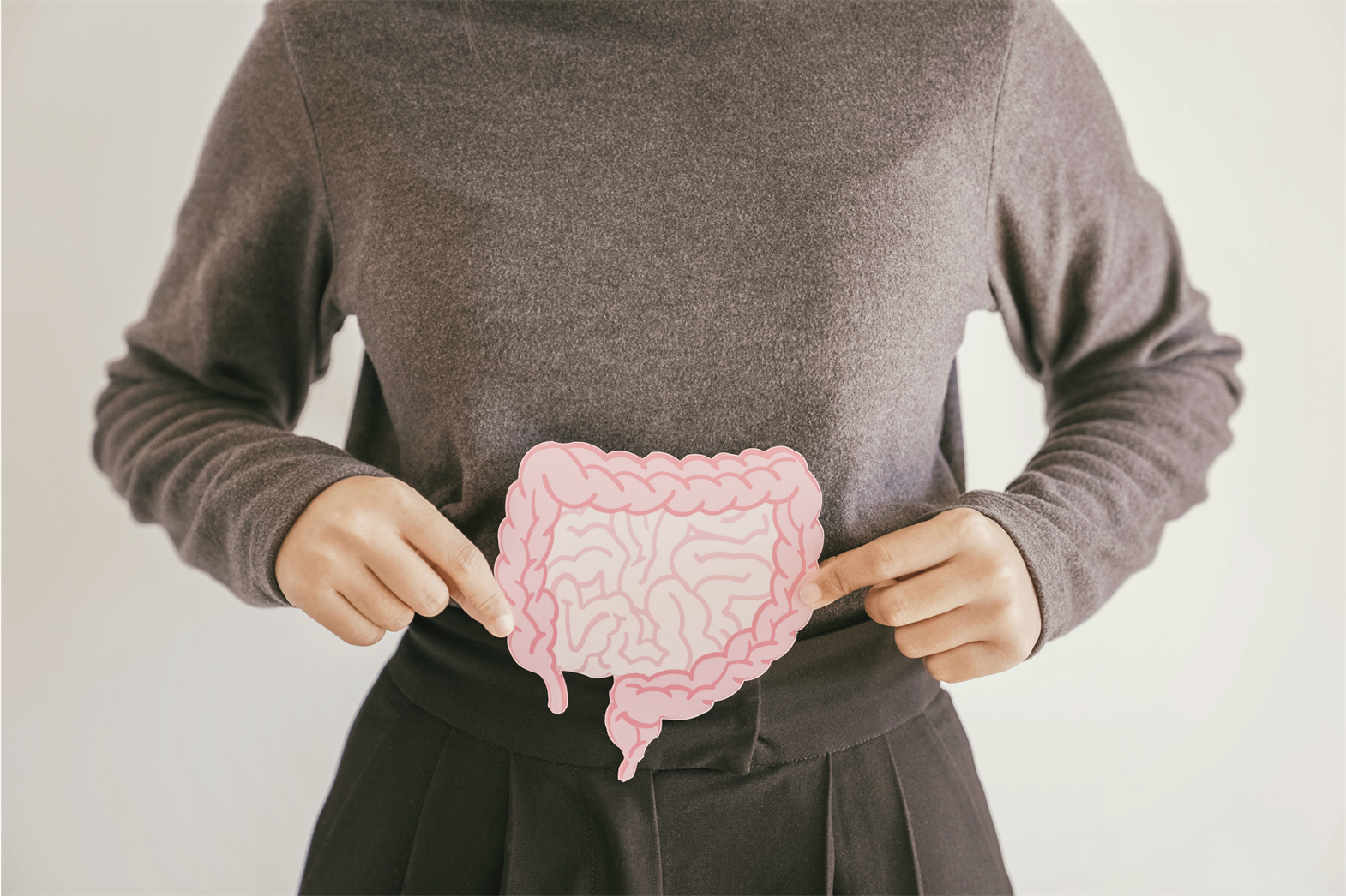 Une femme tenant un dessin du système gastro-intestinal