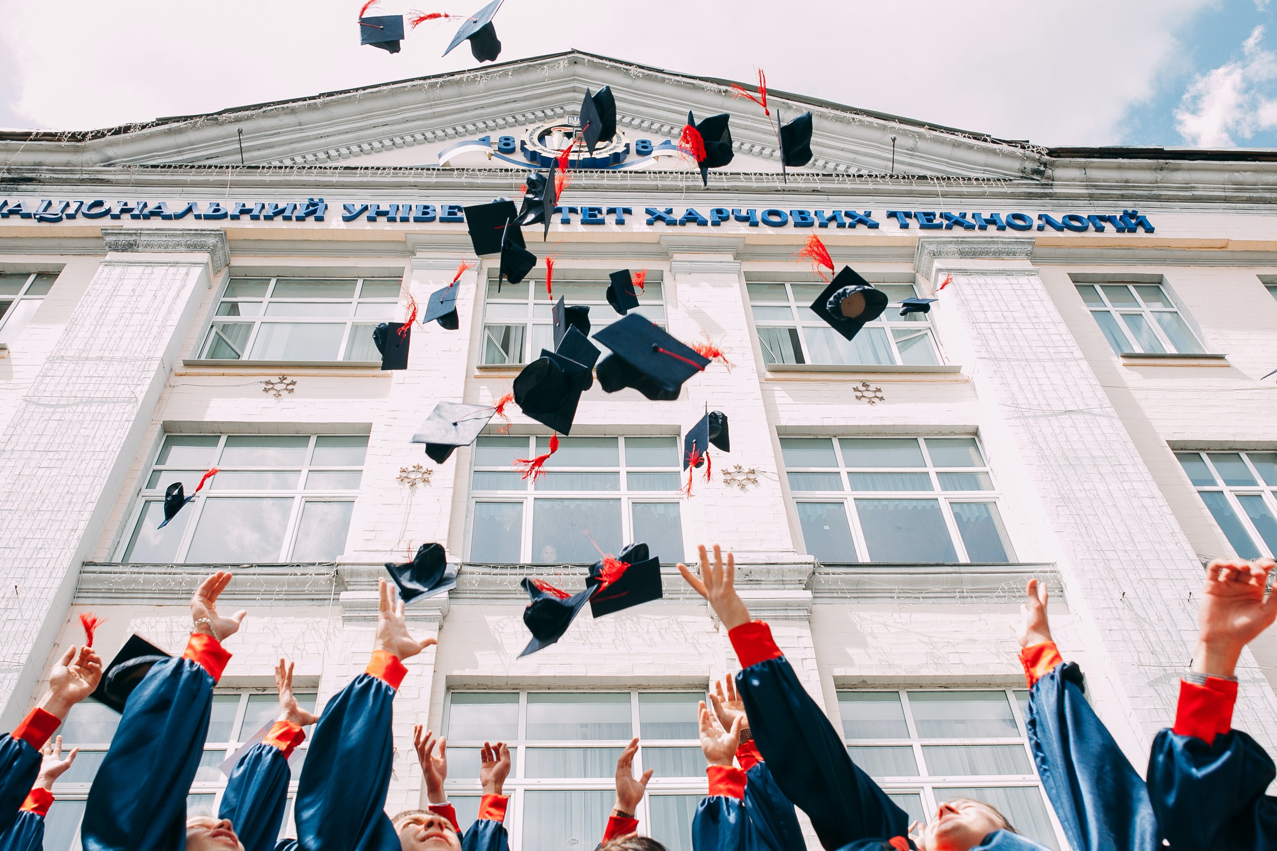 A group of fresh graduates students throwing their academic hat in the air