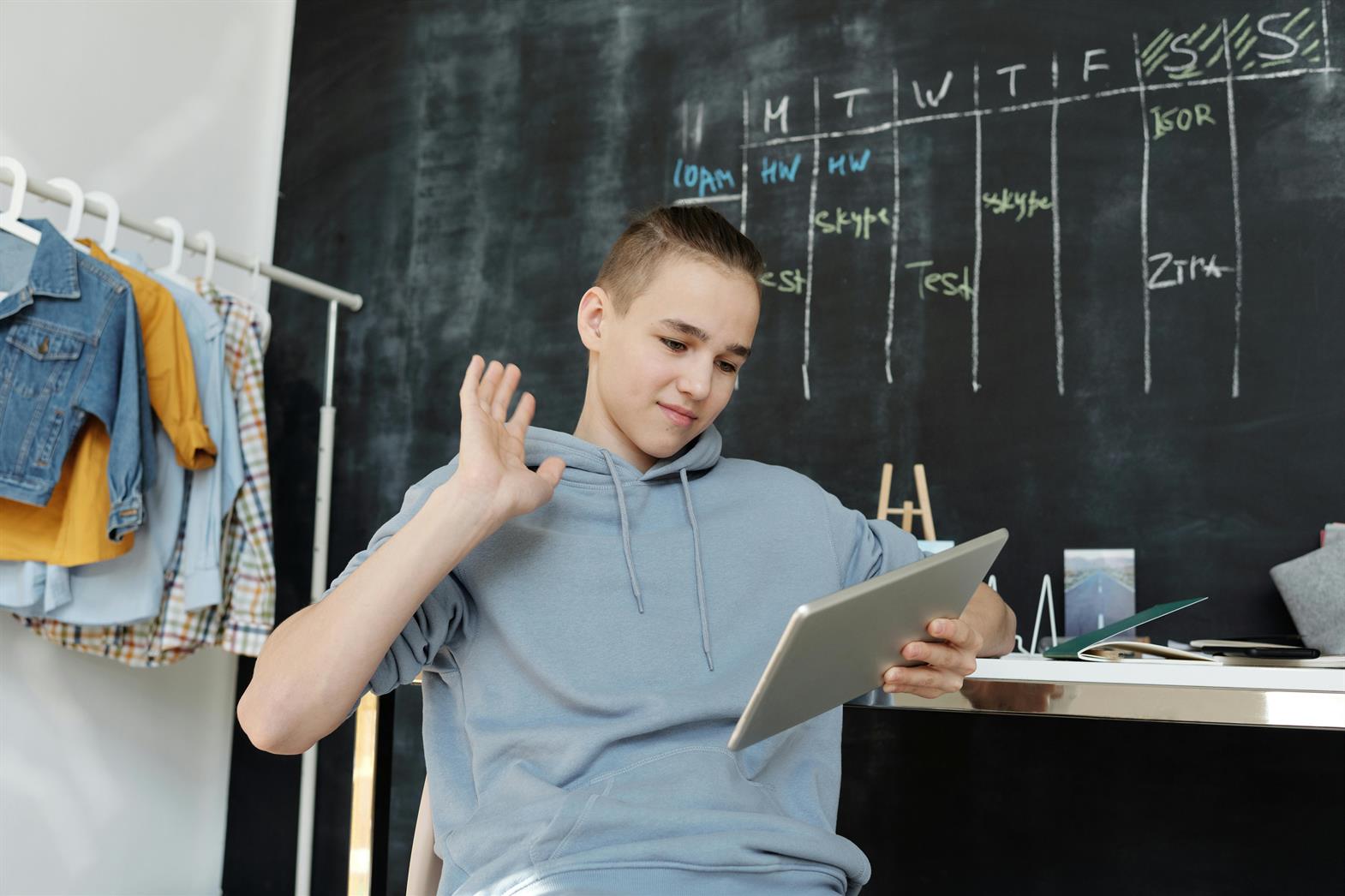 Photo of a Person Wearing Gray Hoodie While Using Tablet
