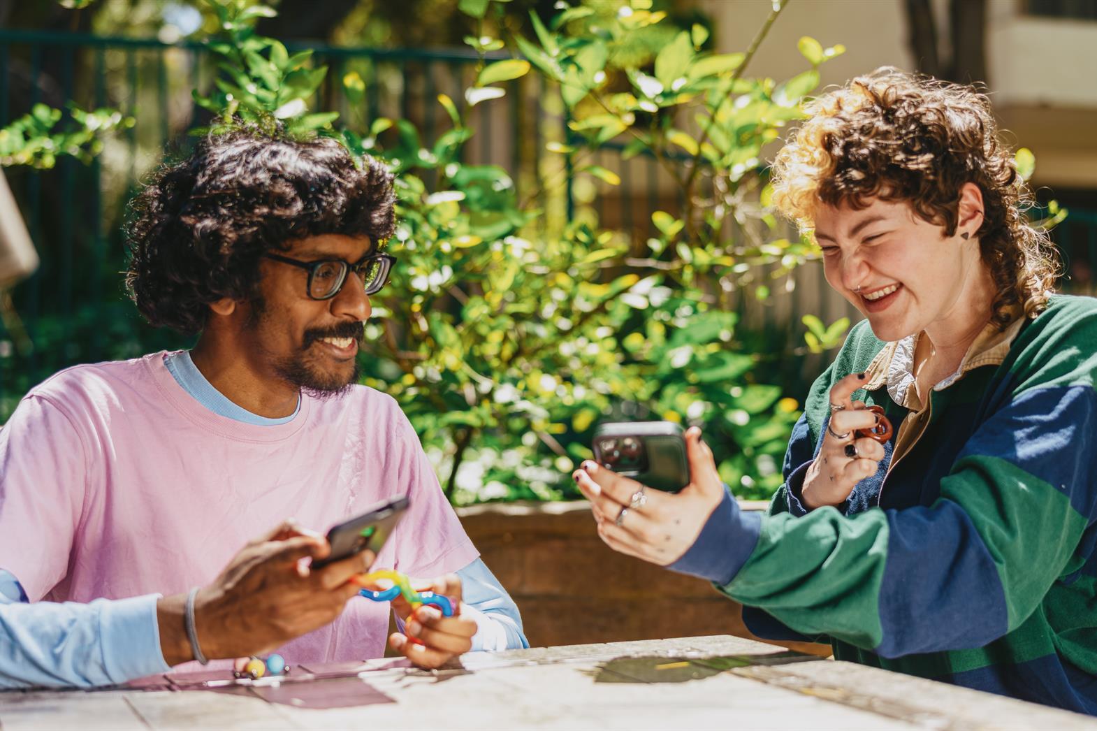 Two friends laughing and playing with fidgets