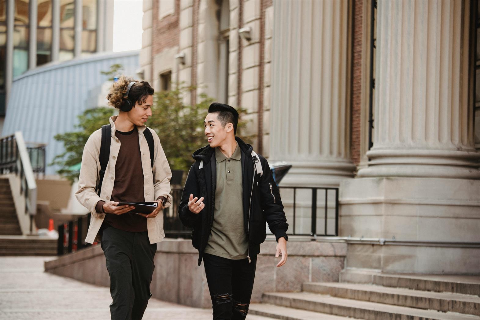 Two young men walking on a university campus outdoors