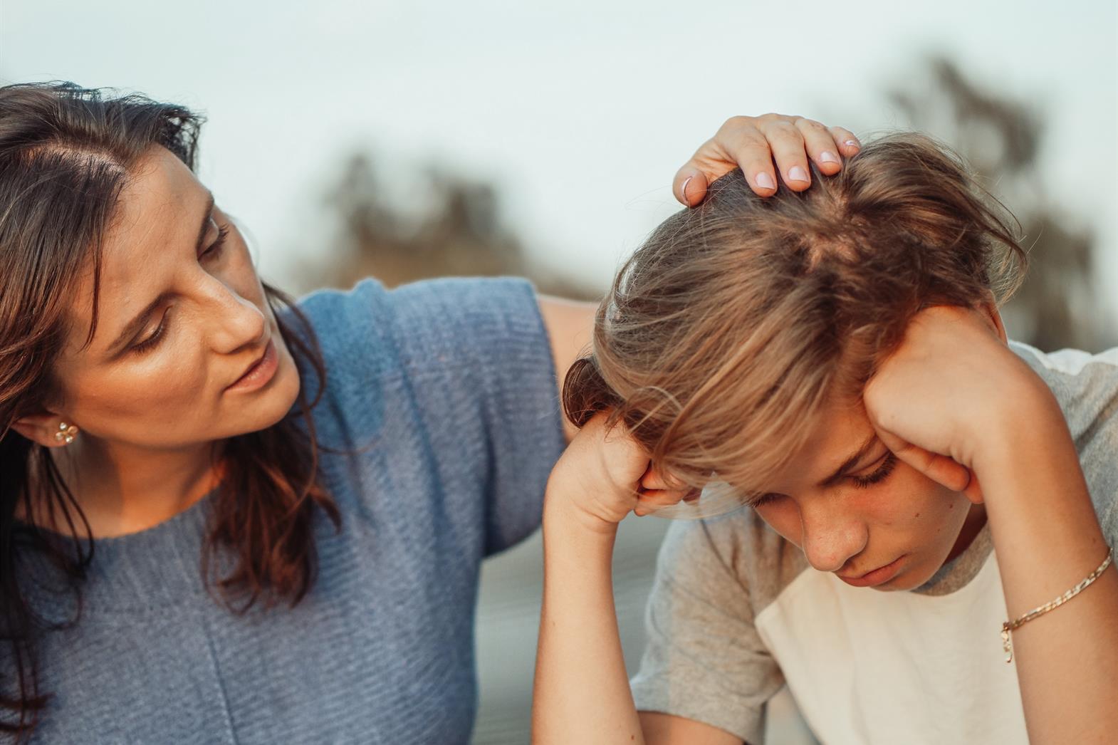 Mother talking to teenager who looks sad