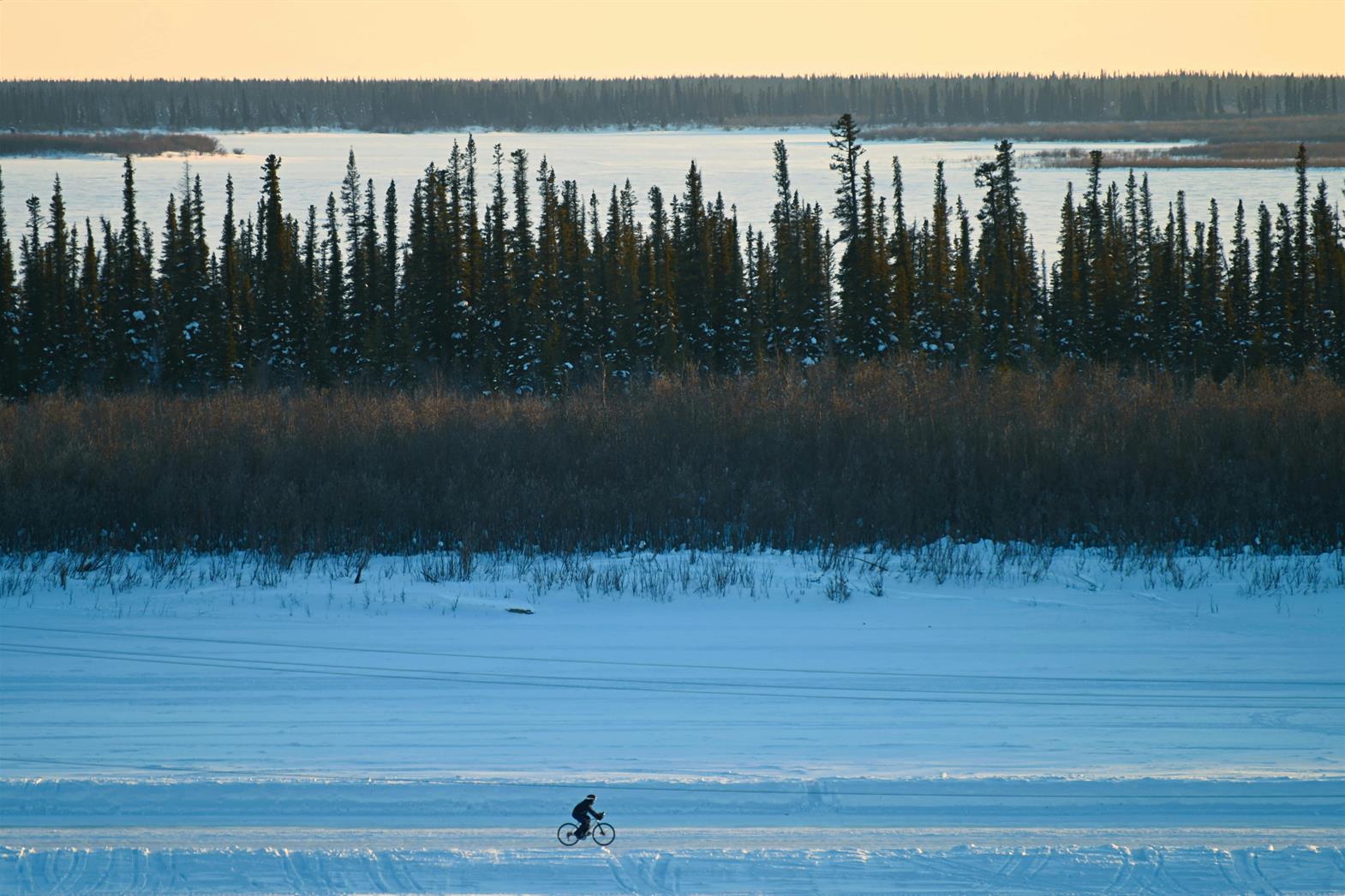 Person Biking on the Snow Covered Ground