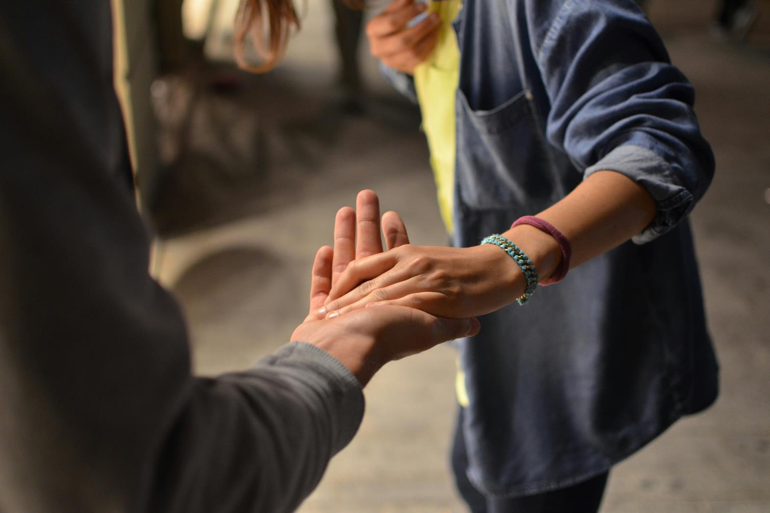 A person holding out a hand supporting another person