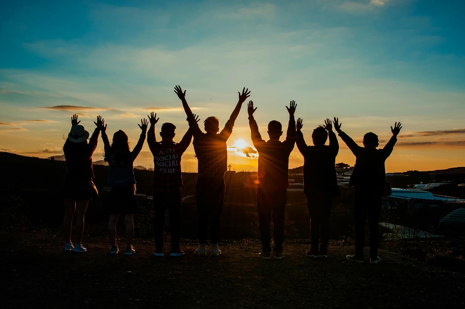 Une photo d'un groupe de personnes silhouettées par un coucher de soleil