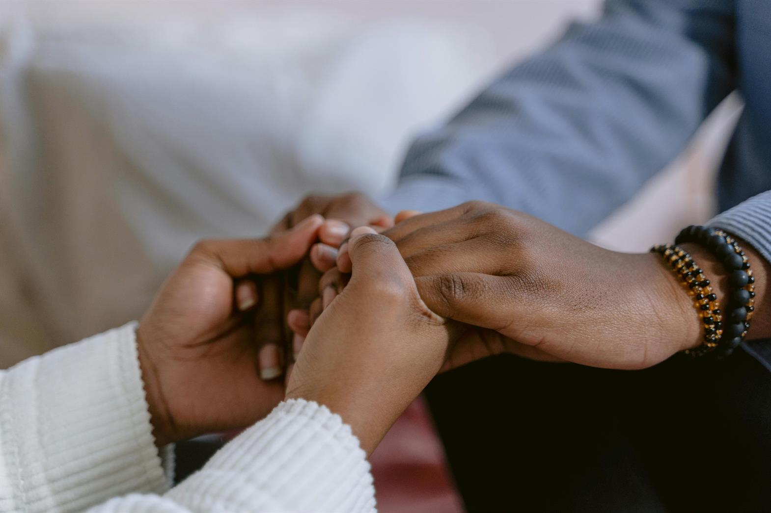A close-up of two people's hands held together in support