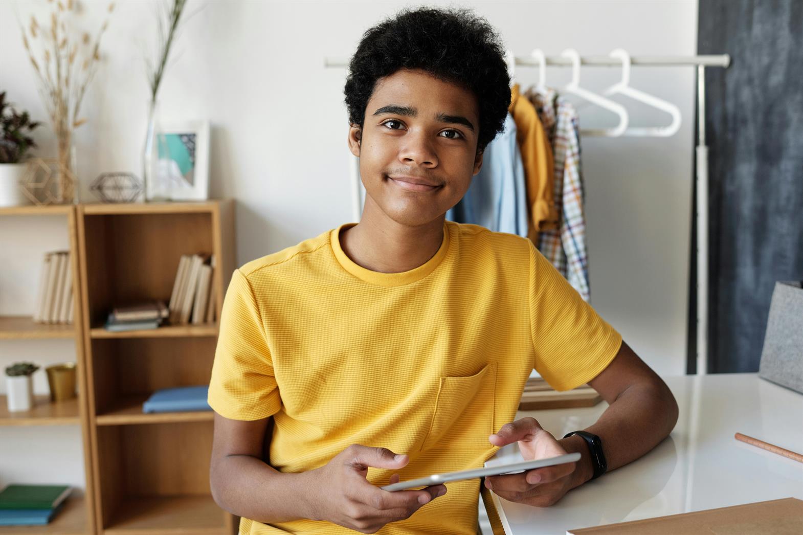 Garçon en T-shirt jaune tenant une tablette
