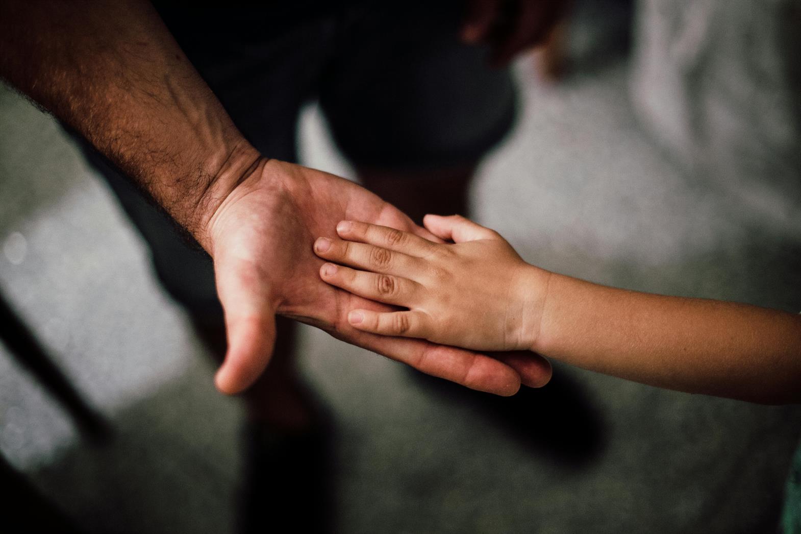 Les mains d'un père et d'un enfant réunies