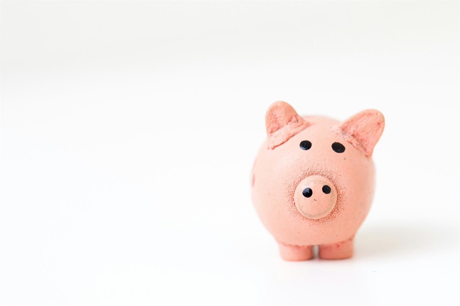 A pink piggy bank on a white surface