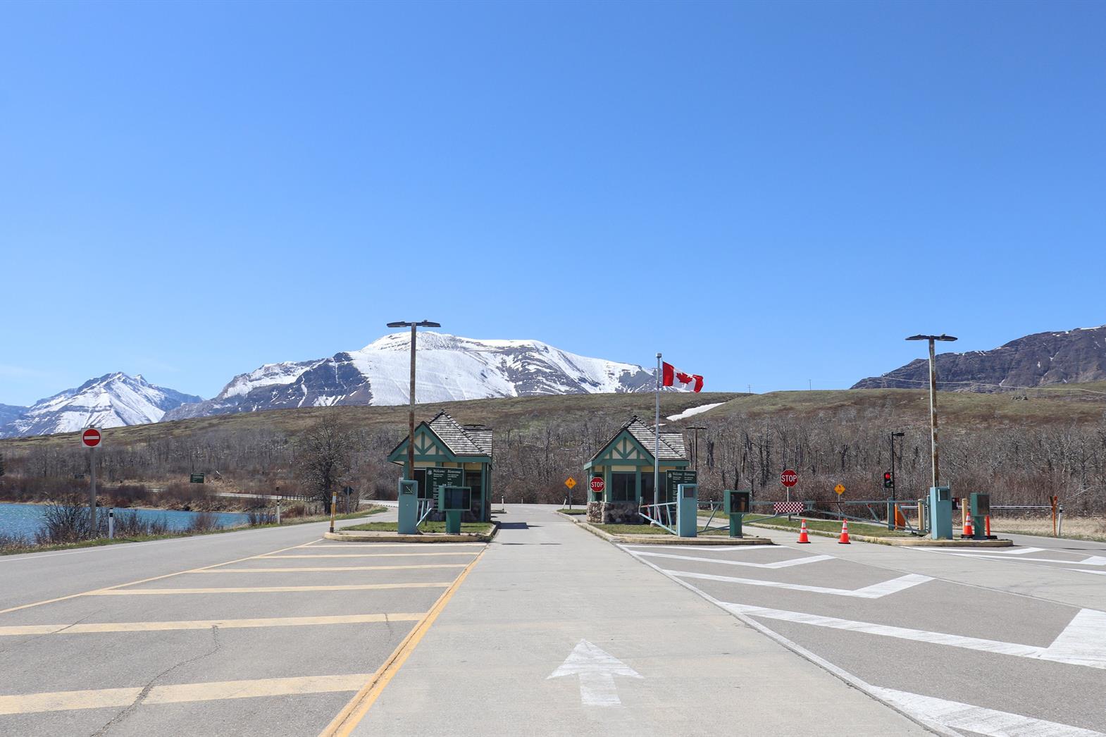 Canadian border crossing amidst stunning snow-capped mountains and clear blue sky