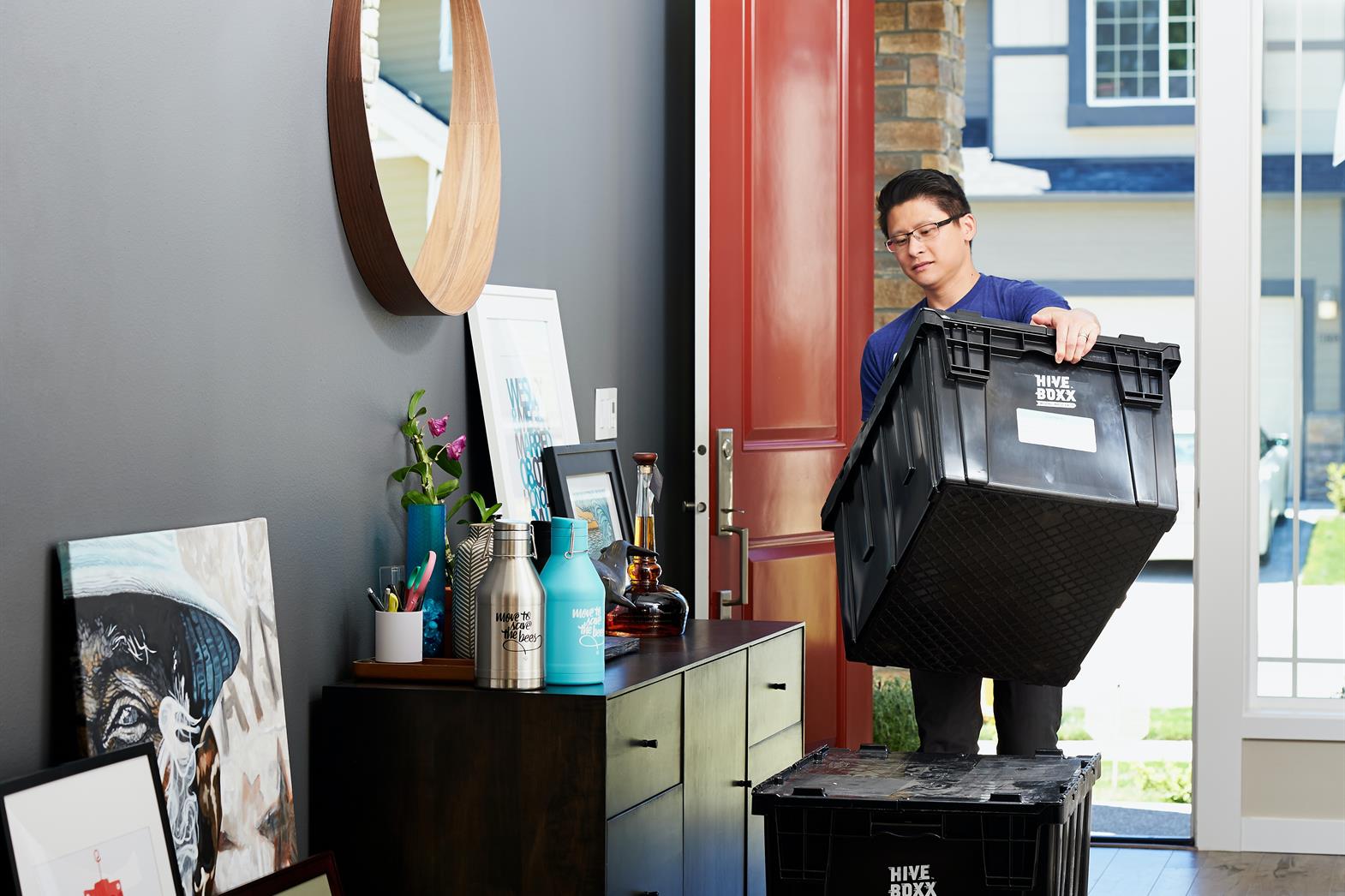 A person carrying a box into a house