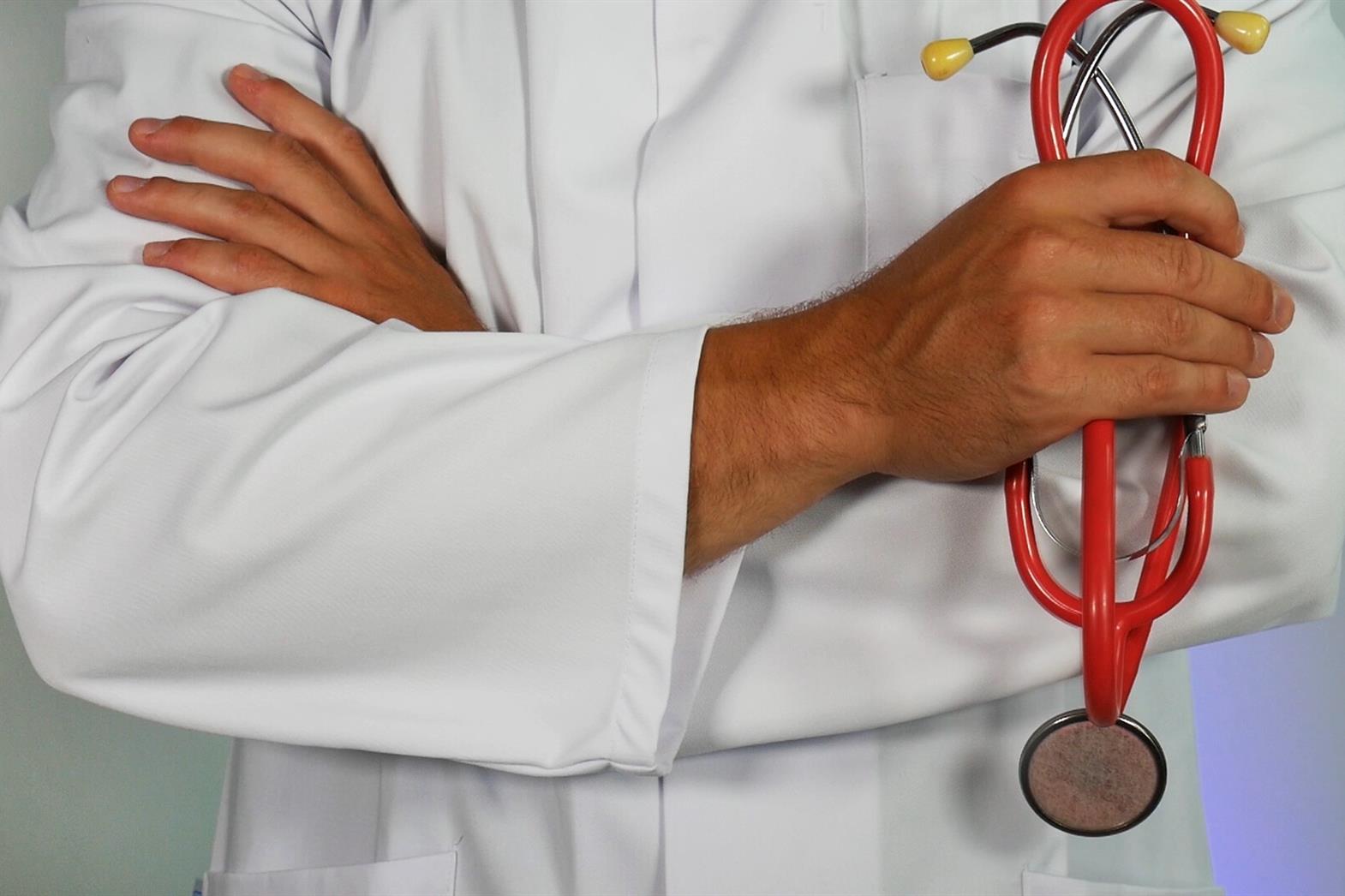 A doctor holding a red stethoscope