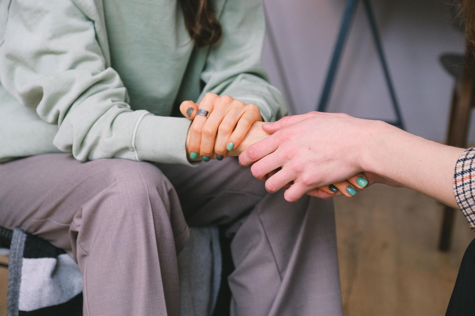 A close-up of two people's hands held together in support