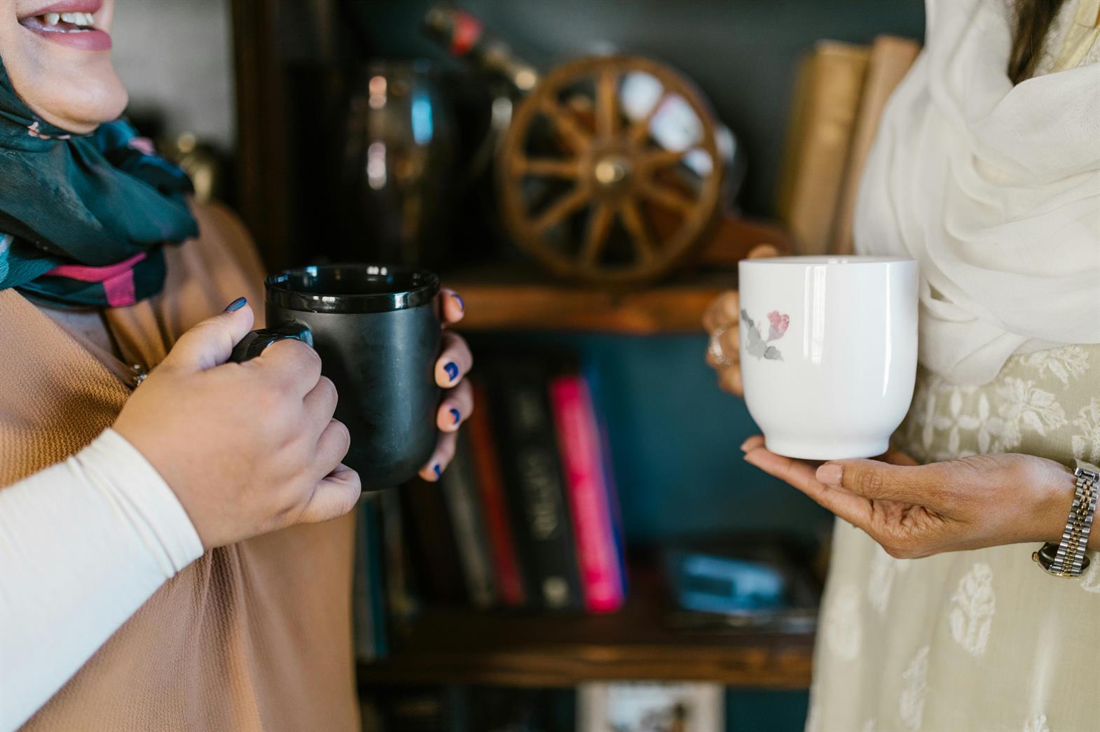 Close-up of Women Talking with Cups of Coffee in Their Hands